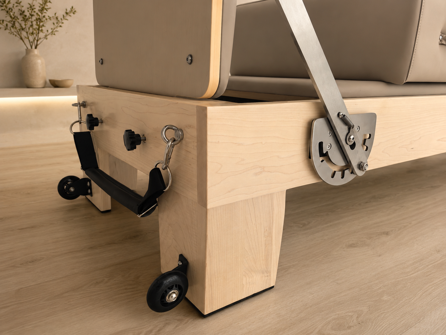 oakwood frame of mushroom coloured reformer in a pilates studio, modern design