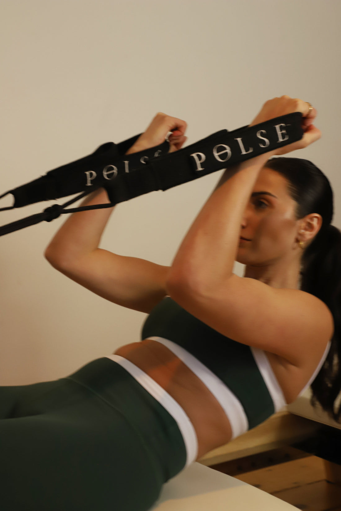 Woman performing advanced Pilates core exercise to build strength and muscle tone.
